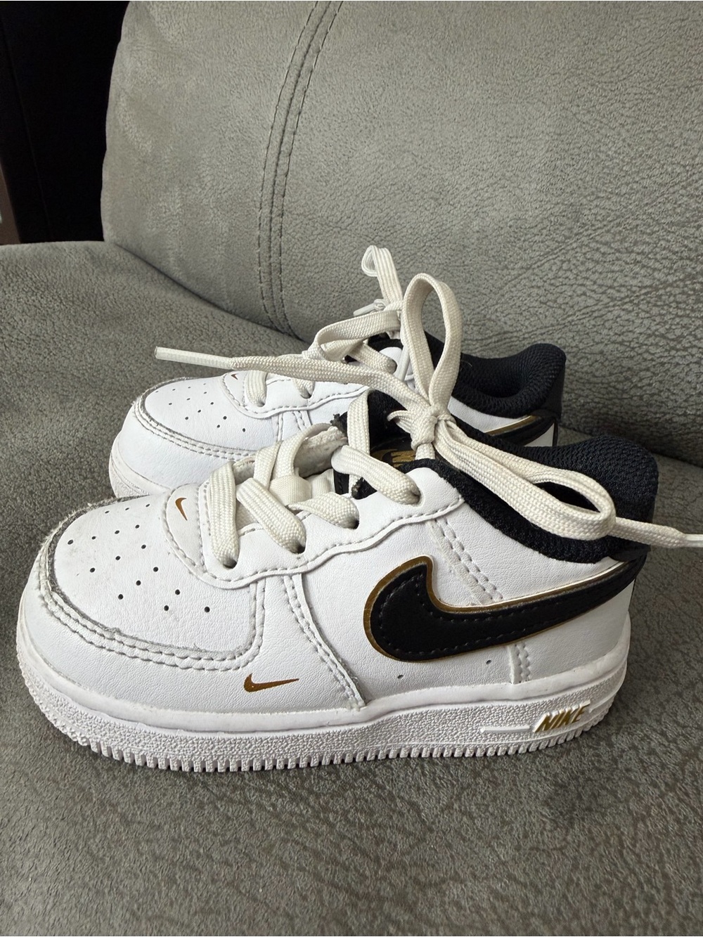 Nike Kids White Sneakers with Black Swoosh and Gold Accents